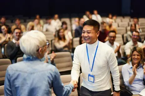 two people shaking hands at a conference event