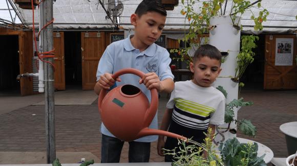 two boys watering plants