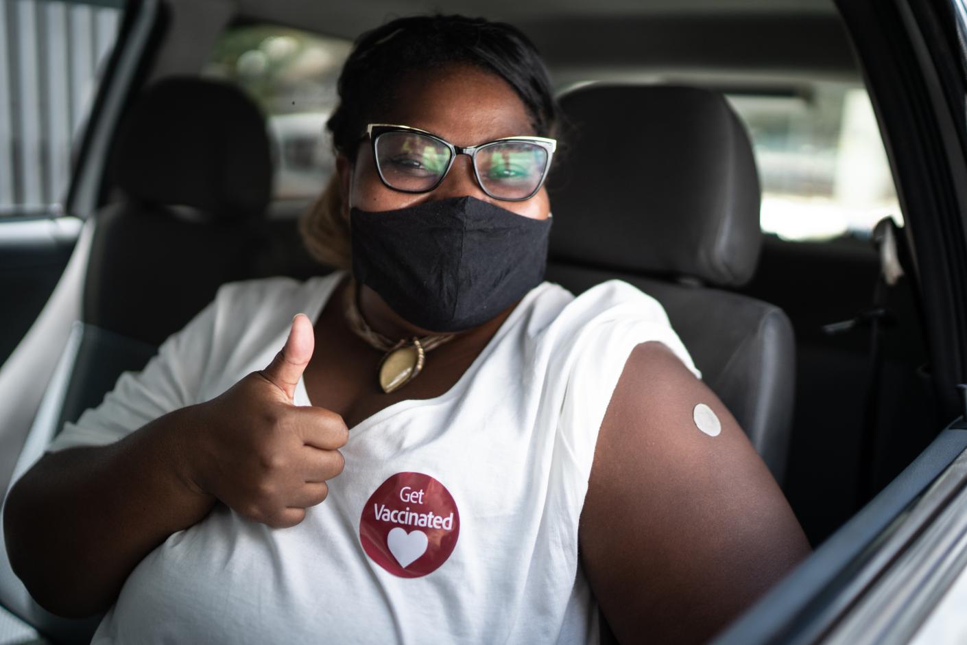 Woman with thumbs up and "Get Vaccinated" sticker