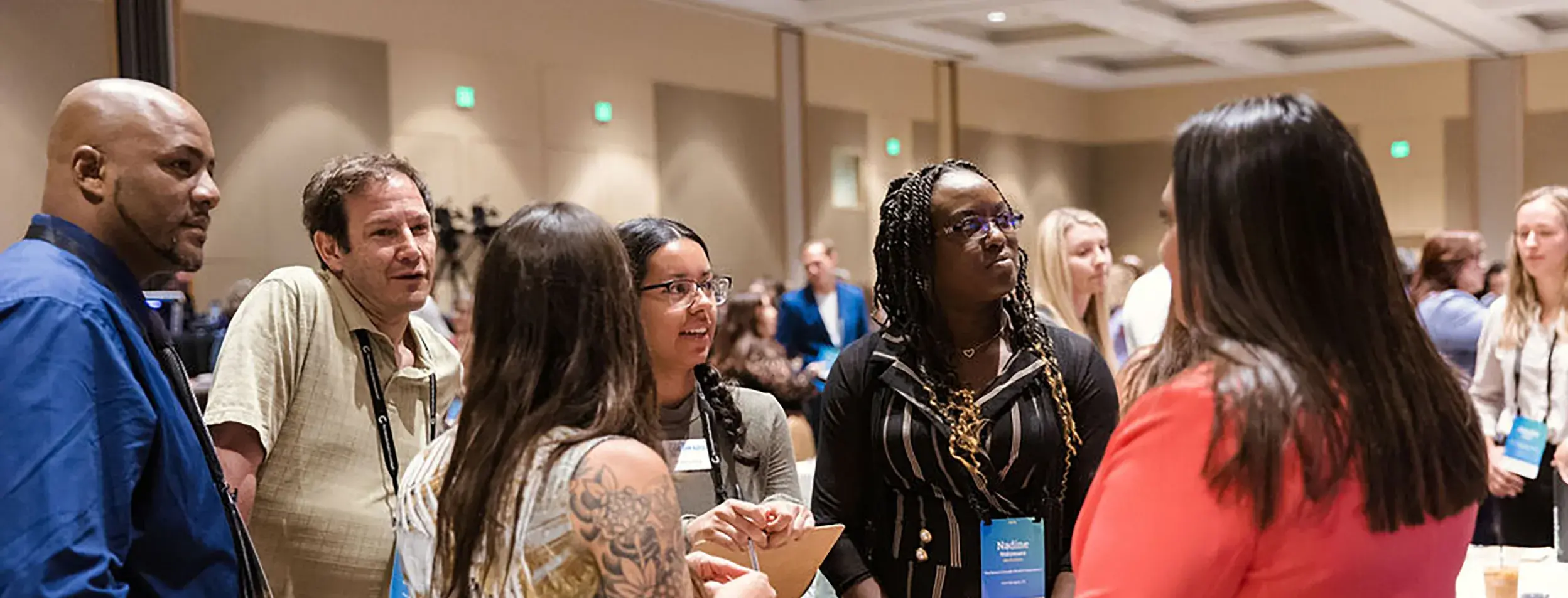 A multiracial group of people talking at the Colorado Health Symposium
