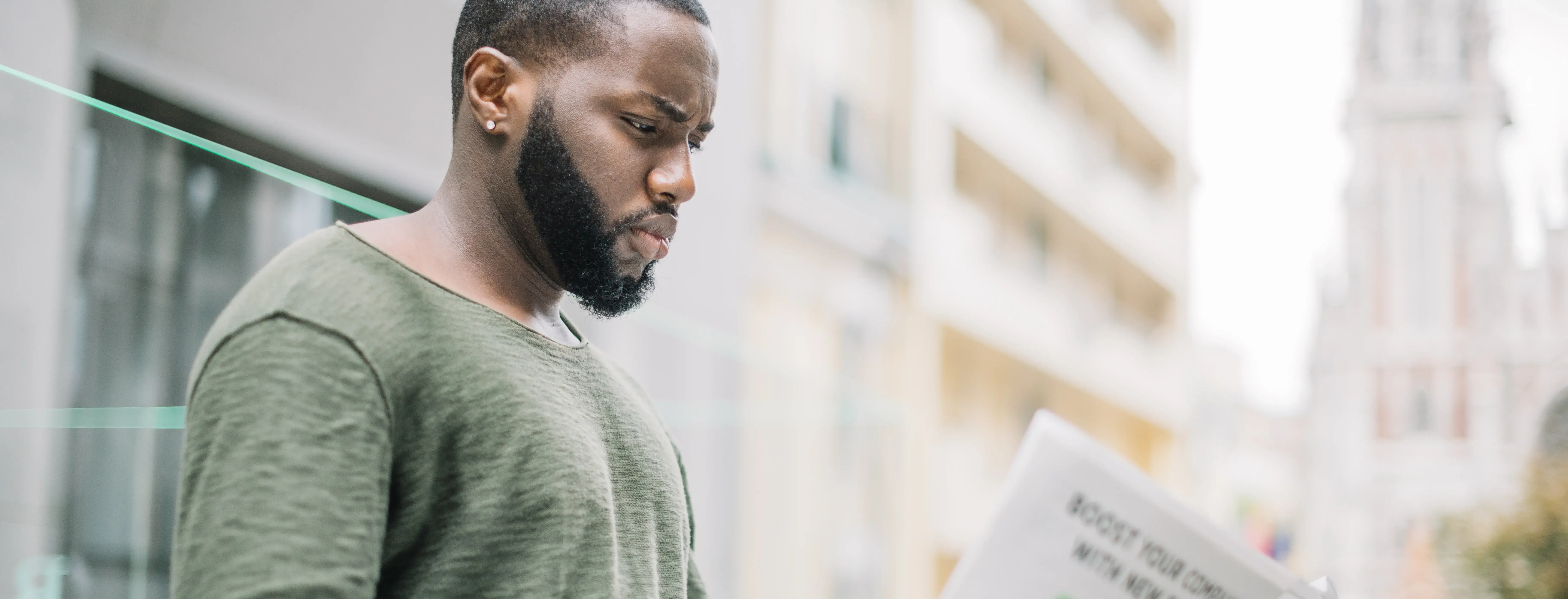 A man on the street reading a newspaper