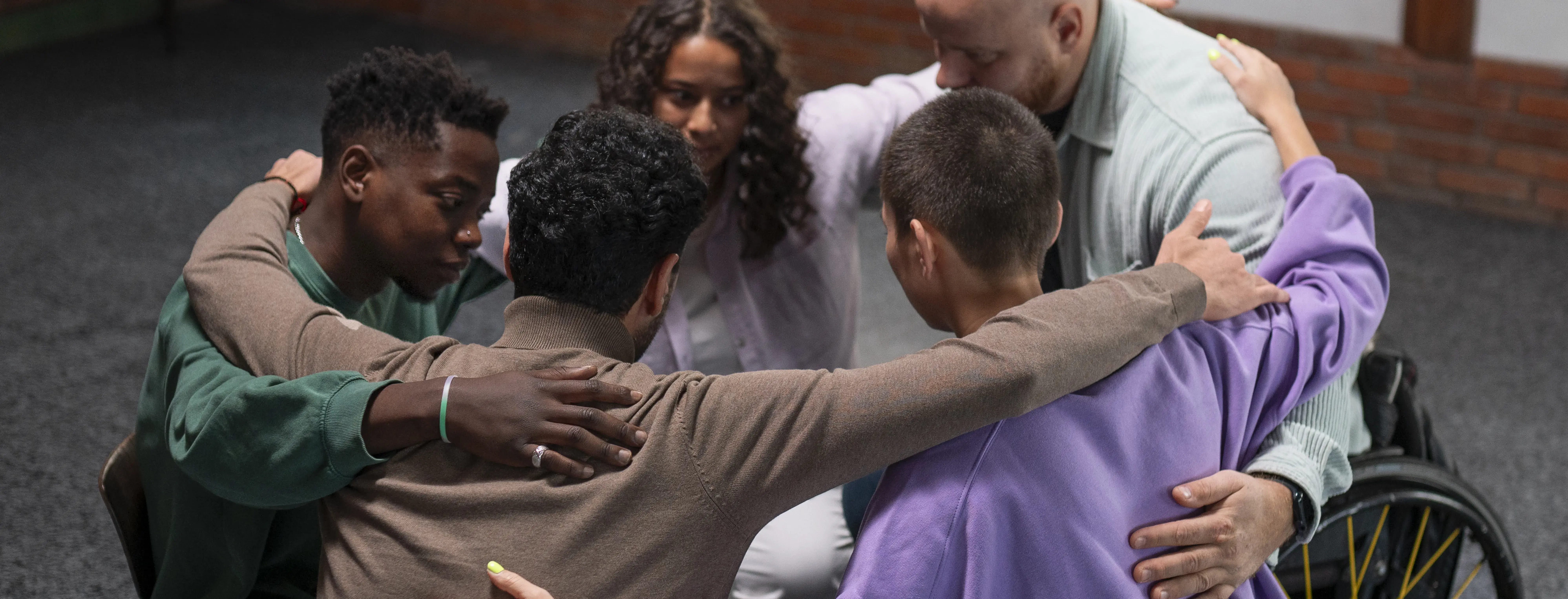 people sitting in a circle engaged in a group hug